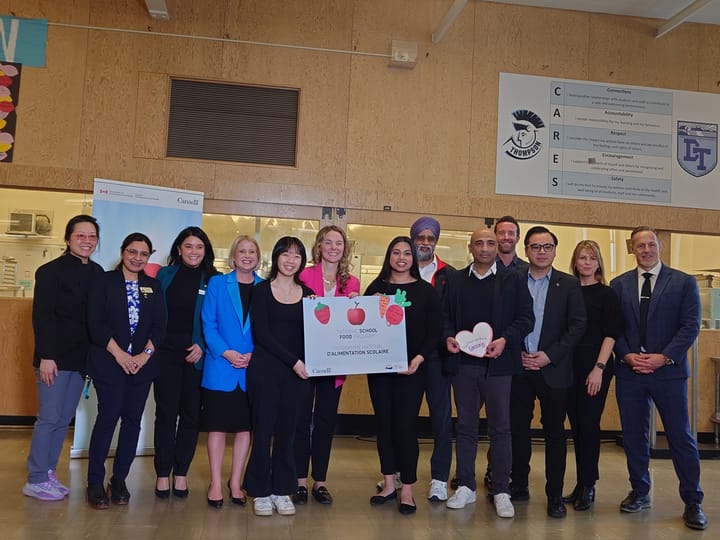 Dignitaries, including Min. Jenna Sudds, Min. Harjit Sajjan, B.C. Min. Lisa Beare gather with students and teachers of David Thompson Secondary School.